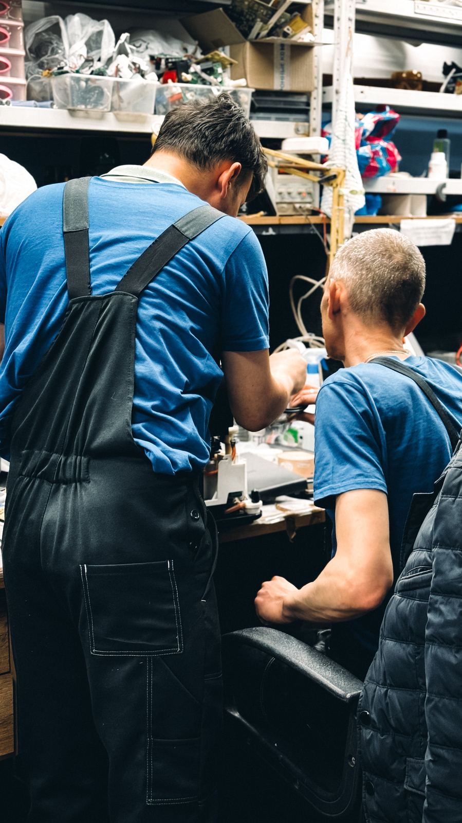 Engineers working together at a busy electronics workbench