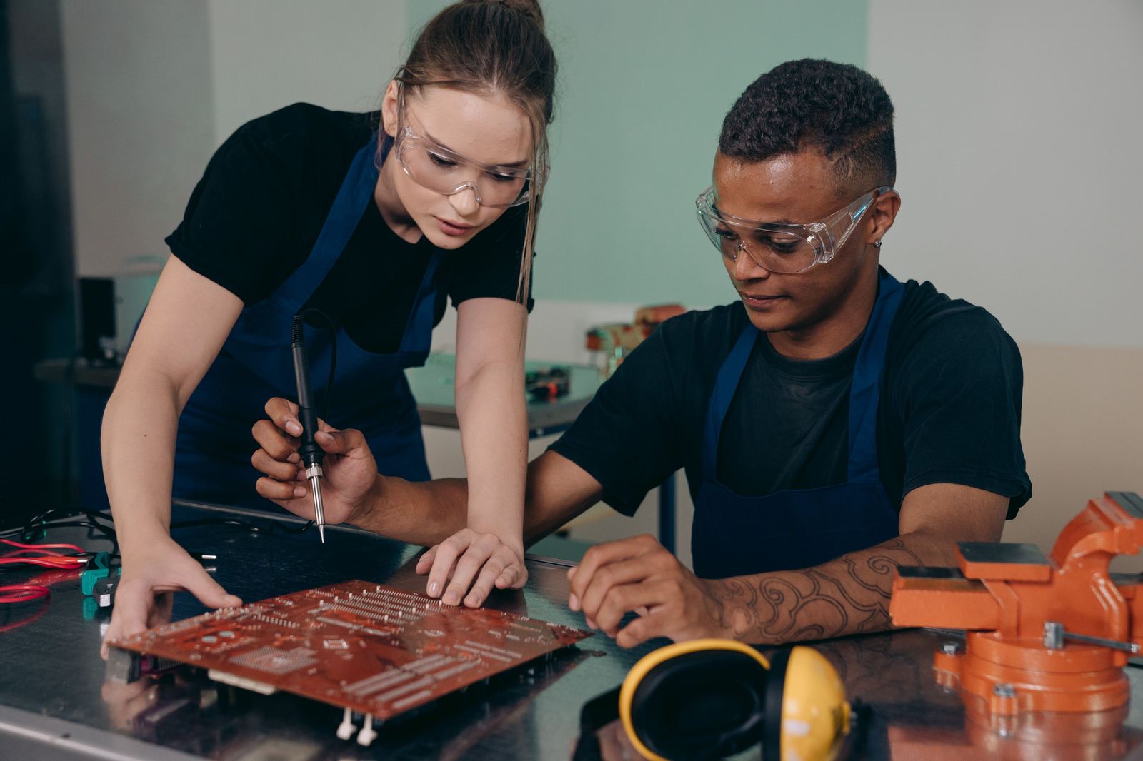 Two engineers soldering a circuit board together