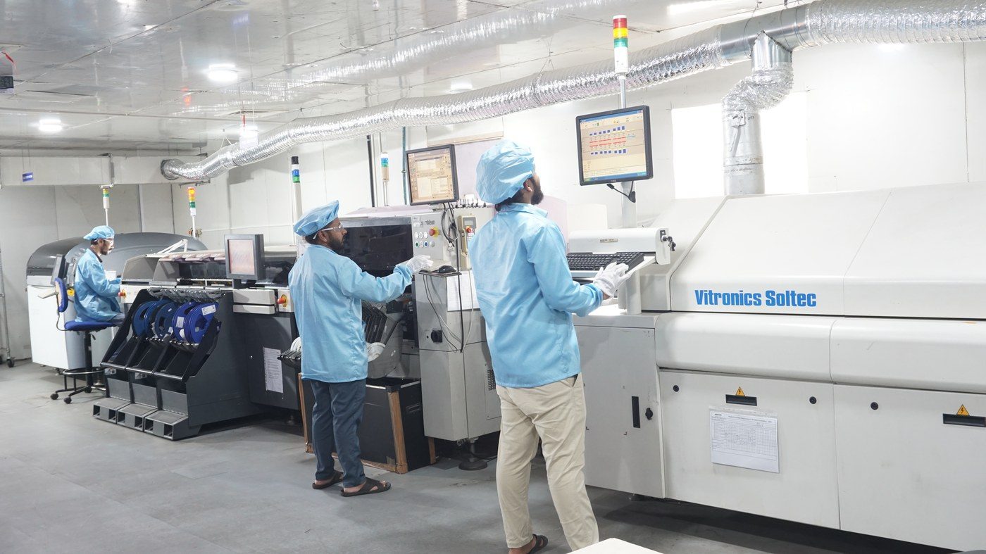 Line operators monitoring the SMT pick-and-place process