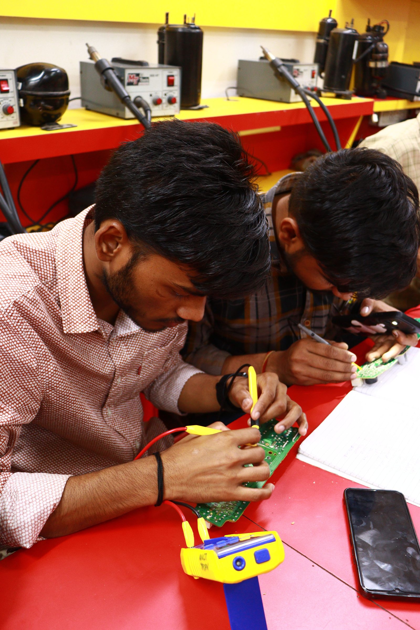 Engineer hand-soldering a populated circuit board