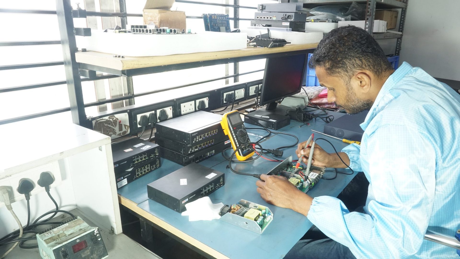 MRO‑TEK technician testing a Cornus switch with a multimeter at the service bench