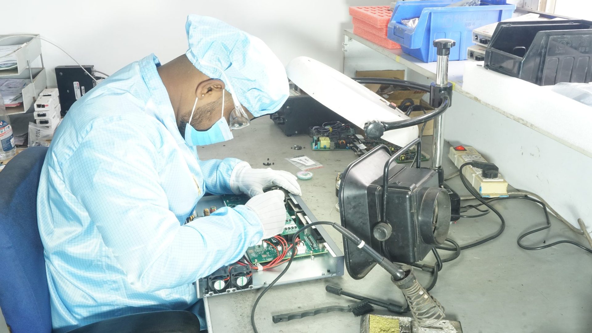 Technician servicing networking hardware on a workbench